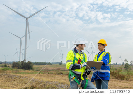 Team engineer of wind turbine worker pointing holding laptop working about renewable Team engineer of wind turbine worker pointing holding laptop working about renewable 118795740