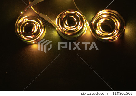 A stack of LED lights on coiled flexible lighting strips, colored yellow. 118801505