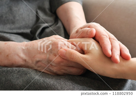 Senior woman's hand holding another woman's hand 118802950