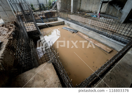 A construction site featuring a large puddle of standing water 118803376