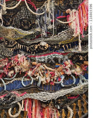 A ropes piece of art is displayed on a wooden wall 118803396