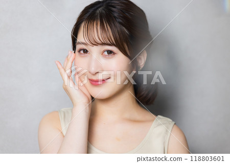 A young woman feels her skin become more moisturized 118803601