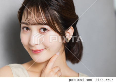 A young woman feels her skin become more moisturized A young woman feels her skin become more moisturized 118803607