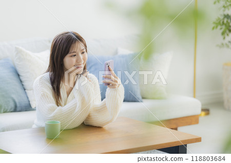 A young woman in knitwear relaxing in a room 118803684