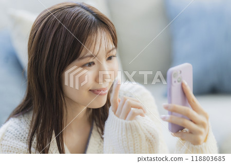 A young woman in knitwear relaxing in a room A young woman in knitwear relaxing in a room 118803685