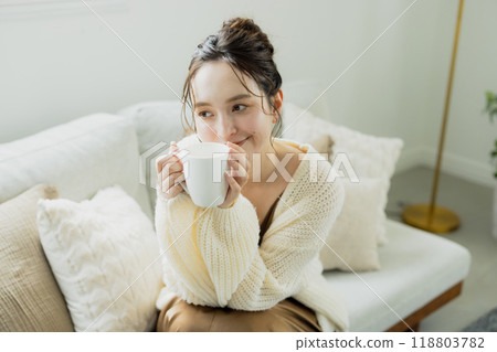 Woman drinking hot coffee in her room 118803782