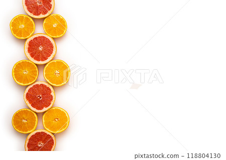 Fresh sliced and halved citrus fruits as a pattern in the left third of the image on a white background. Fresh sliced and halved citrus fruits as a pattern in the left third of the image on a white background. 118804130