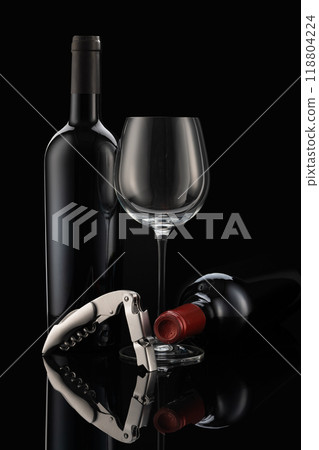 2 wine bottles and a wine glass with a modern corkscrew in front of a black background 118804224