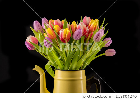 Colorful Bouquet of Tulips in a Yellow Enamel Pot in front of a black background Colorful Bouquet of Tulips in a Yellow Enamel Pot in front of a black background 118804270