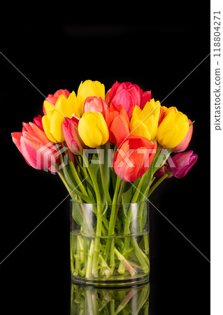 Large colorful bouquet of tulips in big glass vase in front of black background Large colorful bouquet of tulips in big glass vase in front of black background 118804271