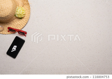 Summer, beach and vacation concept with free text space. Top view. Flat layout with women straw, sun glasses hat and a smartphone with wireless earphones on a fine sandy background Summer, beach and vacation concept with free text space. Top view. Flat layout with women straw, sun glasses hat and a smartphone with wireless earphones on a fine sandy background 118804753