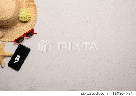 Summer, beach and vacation concept with free text space. Top view. Flat layout with women straw hat, sun glasses, see star and a smartphone with wireless earphones on a fine sandy background Summer, beach and vacation concept with free text space. Top view. Flat layout with women straw hat, sun glasses, see star and a smartphone with wireless earphones on a fine sandy background 118804754