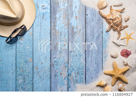 Summer, beach and vacation concept with free text space. Top view. Flat layout with a man straw hat, sun glasses, large sea star and sea shell and various sea shells and fine beach sand on an old blue 118804927