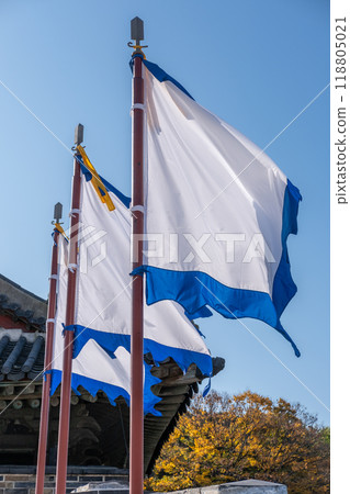 White and blue flag, at Suwon Hwaseong Fortress Wall, with the park view during autumn. The wall is surrounding the center of Suwon, the provincial capital of Gyeonggi-do, in South Korea White and blue flag, at Suwon Hwaseong Fortress Wall, with the park view during autumn. The wall is surrounding the center of Suwon, the provincial capital of Gyeonggi-do, in South Korea 118805021