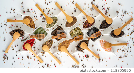 Many different spices in porcelain bowls with wooden spoons Many different spices in porcelain bowls with wooden spoons 118805990