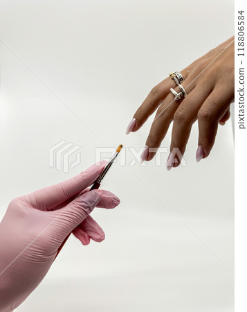 Close-up of a Gloved Hand Applying Nail Polish to a Client Nails. High quality photo Close-up of a Gloved Hand Applying Nail Polish to a Client Nails. High quality photo 118806584