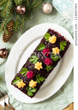 Christmas appetizer New year meal idea. Festive layered salad. Christmas New Year vegetable salad roll with herring and boiled vegetables. 118807464