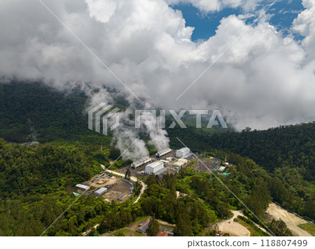 Mountain forest with Geothermal station with steam and pipes. Renewable energy production at a power station. Mindanao, Philippines. Aerial drone shot. 118807499
