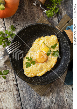 Khachapuri, baked cottage cheese pumpkin bread with cheese and egg filling on rustic wooden table. Georgian cuisine meal. Khachapuri, baked cottage cheese pumpkin bread with cheese and egg filling on rustic wooden table. Georgian cuisine meal. 118807567