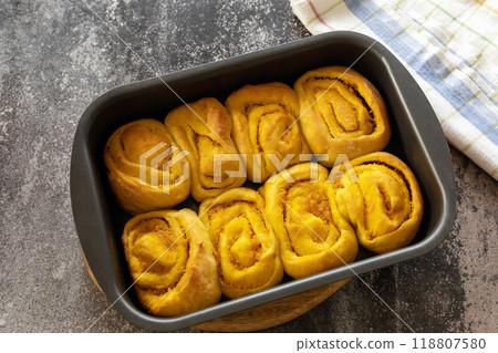 Instruction step 11. Freshly baked pumpkin cinnamon rolls or cinnabon with cream cheese on a rustic wooden table. Homemade seasonal autumn homemade pastry. 118807580