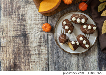 Chocolate rum potato cake with pumpkin on rustic background, homemade vegan dessert. Traditional Eastern European dish with cocoa and butter. Chocolate sweets filled with marzipan. View from above. Chocolate rum potato cake with pumpkin on rustic background, homemade vegan dessert. Traditional Eastern European dish with cocoa and butter. Chocolate sweets filled with marzipan. View from above. 118807653