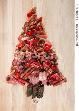 Christmas tree made of sausage on a background of a wooden wall Christmas tree made of sausage on a background of a wooden wall 118807892