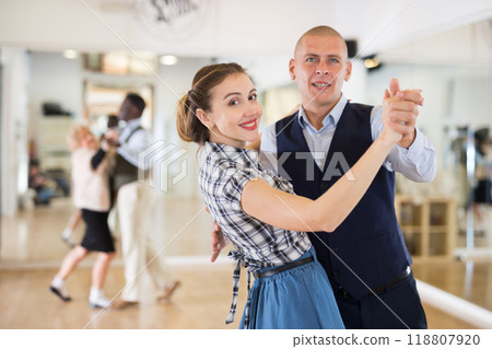 Happy man and woman enjoying ballroom dancing 118807920