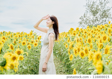 Portrait of a woman in a sunflower field Portrait of a woman in a sunflower field 118808015