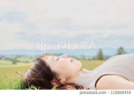 A young woman lying down with nature in the background A young woman lying down with nature in the background 118808459
