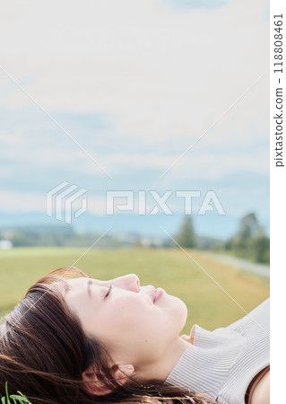 A young woman lying down with nature in the background 118808461