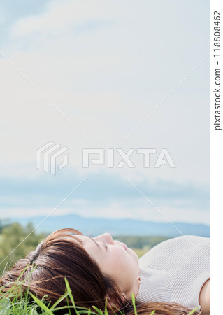 A young woman lying down with nature in the background 118808462