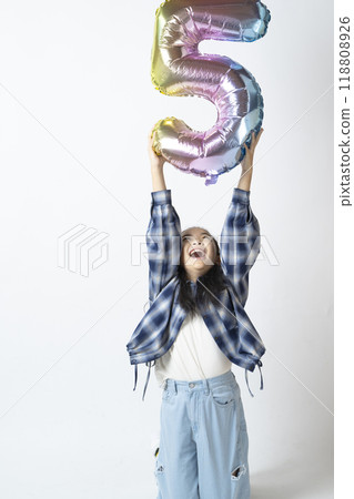 Elementary school girl holding the number 5 in her hand 118808926