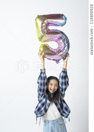 Elementary school girl holding the number 5 in her hand 118808928