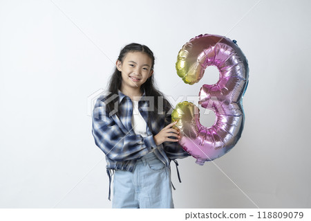 Elementary school girl holding the number 3 in her hand Elementary school girl holding the number 3 in her hand 118809079