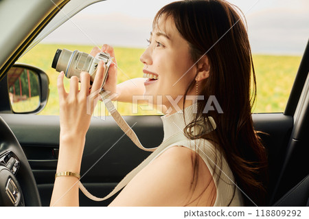 Young woman taking a photo from inside the car 118809292