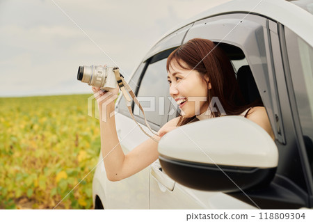 Young woman taking a photo from inside the car 118809304