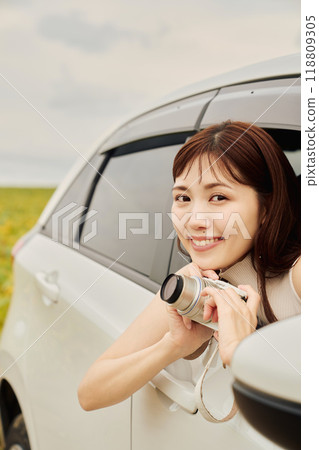 Young woman taking a photo from inside the car 118809305
