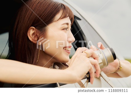 Young woman taking a photo from inside the car 118809311