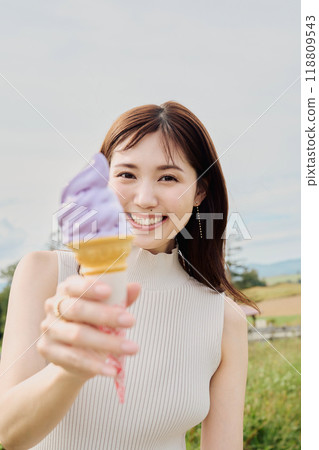 A woman eating a soft cream 118809543
