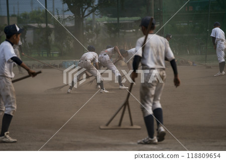 After practice, baseball team members prepare the field. After practice, baseball team members prepare the field. 118809654