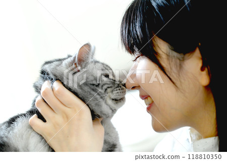 Beautiful young Asian woman touching a cat Beautiful young Asian woman touching a cat 118810350
