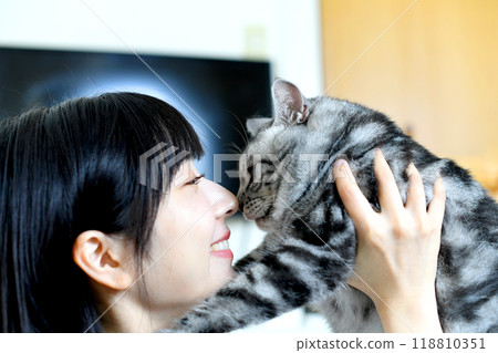 Beautiful young Asian woman touching a cat Beautiful young Asian woman touching a cat 118810351