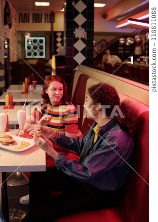 Enjoying Delicious Meal in Retro Diner Setting Enjoying Delicious Meal in Retro Diner Setting 118811088
