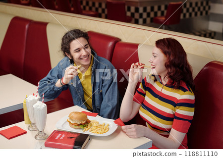 Smiling Friends Eating Snacks in Retro Diner Booth Smiling Friends Eating Snacks in Retro Diner Booth 118811110