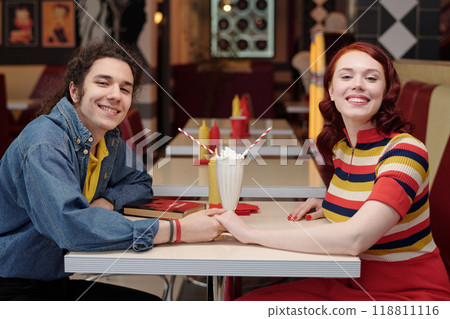 Smiling Couple Holding Hands in Retro Diner Setting Smiling Couple Holding Hands in Retro Diner Setting 118811116