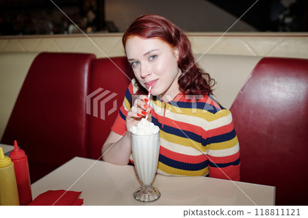 Portrait of Young Woman Drinking Milkshake at Diner Booth Portrait of Young Woman Drinking Milkshake at Diner Booth 118811121