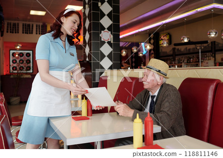 Smiling Waitress Serving Food to Elderly Man in Diner 118811146