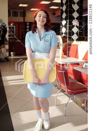 Portrait of Smiling Waitress Standing in Retro Diner 118811148