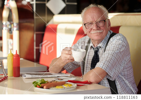 Portrait of Elderly Man Sitting in Diner Holding Coffee Cup 118811163
