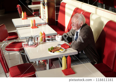 Eating Breakfast at Classic Diner with Red Seating Booths Eating Breakfast at Classic Diner with Red Seating Booths 118811181